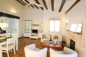 uma sala de estar com mobiliário branco e uma mesa em Puerto Azul Casa Doro em Denia