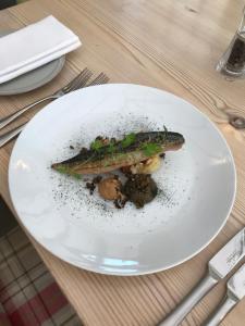 un plato blanco con un pez en una mesa en The Dog At Wingham, en Wingham
