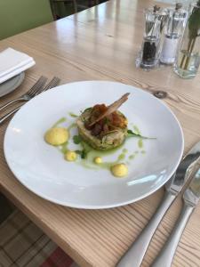 a white plate with food on a table at The Dog At Wingham in Wingham