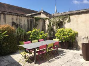 a table and chairs in a yard with a patio at Le Clos Millot in Beaune