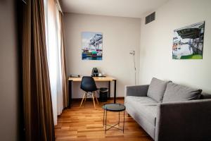 a living room with a couch and a desk at Royal Hotel - Urban Living in Basel