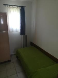 a bedroom with a green bed and a window at Bungalow Gambaro 2 in Cavallino-Treporti