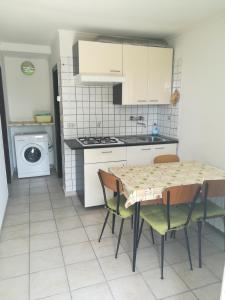 a kitchen with a table and chairs and a stove at Bungalow Gambaro 2 in Cavallino-Treporti