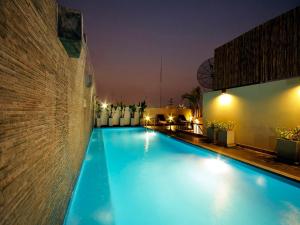 a swimming pool in a building at night at Sleep Withinn in Bangkok