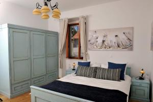 a bedroom with a bed with blue cabinets at Grandpa Mate House in Dragove