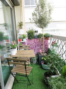 パリにあるApartment Family Lenoir CityCosyの木製ベンチ2台と鉢植えの植物が備わるパティオ