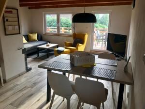 a living room with a table and chairs and a couch at Chata Dandelion in Černá v Pošumaví