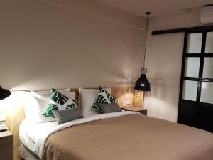 a bedroom with a bed with green and white pillows at Treevana Club Chiangmai in Chiang Mai
