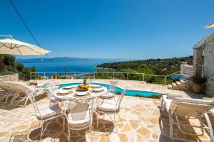 a patio with a table and chairs next to a pool at Waterfalls in Gaios