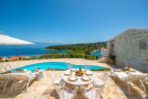 a patio with a table and chairs and a pool at Waterfalls in Gaios