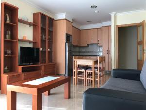 cocina y sala de estar con sofá y mesa en Apartamentos Lúa, en Portonovo