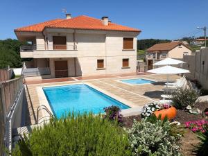 a house with a swimming pool in front of it at Apartamentos Lúa in Portonovo