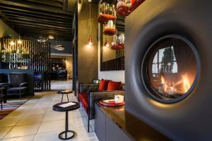 a bar with a fireplace in the middle of a room at Hôtel Les Dames du Panthéon in Paris
