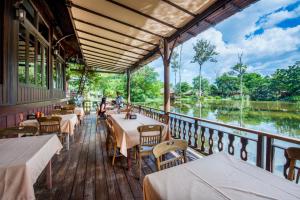 un restaurante con mesas y sillas y vistas al río en Vana Varin Resort, en Hua Hin