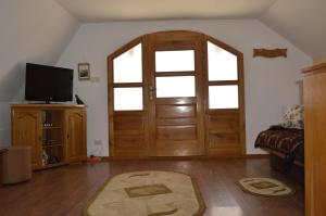 a living room with a wooden door and a tv at Casa Vlasea Albesti Sighișoara in Sighişoara