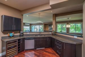 a large kitchen with brown cabinets and a counter top at Luxury Penthouse Downtown Nanaimo in Nanaimo
