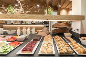 un buffet de diferentes tipos de comida en una mesa en Anewandter Historic Hotel, en Brunico