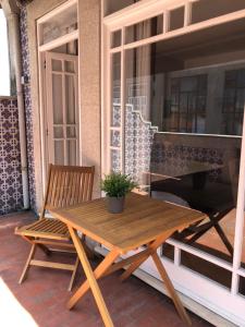 Be Oporto Apartments Clérigos في بورتو: طاولة خشبية ومقعد على الفناء