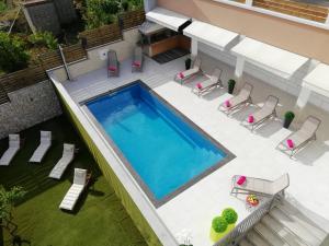 einen Blick über einen Pool mit Gartenmöbeln und einem Pool in der Unterkunft Apartments Villa Katija in Drvenik