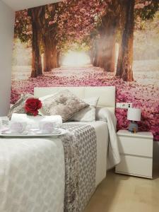 1 dormitorio con 1 cama con un mural de árboles en la pared en Apartamento Ciudad del Tajo, en Ronda