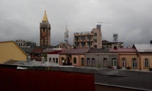 a view of a city with a clock tower and buildings at Old Street Guesthouse in Batumi