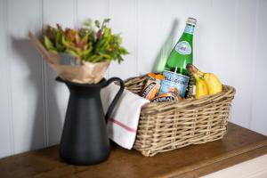 einen Korb mit Essen, eine Flasche Bier und eine Vase in der Unterkunft Beautiful, Secluded Shepherd's Hut in the National Park in Rake