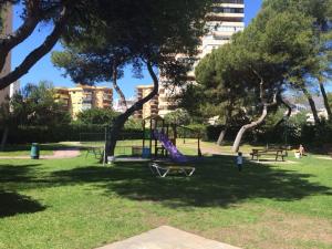 un parc avec une aire de jeux avec un toboggan et des arbres dans l'établissement Playamar10 Stays, à Torremolinos