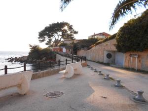 Une rangée de bancs dans une rue à côté de l'océan dans l'établissement t2 bord de mer au calme, à Bandol