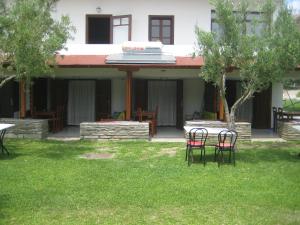 a table and chairs in front of a house at Petradaki Apartments in Mola Kalyva