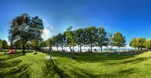 a park with people sitting in the grass at Fenyves Ferienhaus 1 **** in Balatonfenyves +5 photos