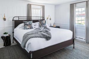 a bedroom with a bed with a blanket and pillows at The Coonamessett in Falmouth