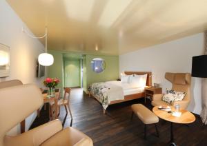 ein Hotelzimmer mit einem Bett, einem Tisch und Stühlen in der Unterkunft Hotel Hof Weissbad in Weissbad