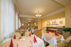 een restaurant met twee tafels met rode servetten bij Hotel Luisa in Františkovy Lázně