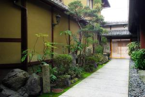 an asian garden with rocks and plants next to a building at Nissho Besso in Kyoto