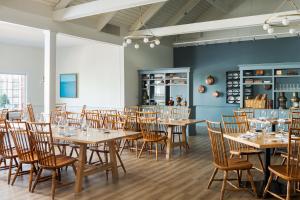a dining room with wooden tables and chairs at The Coonamessett in Falmouth