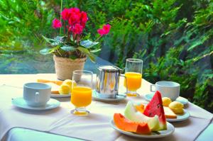 una mesa con platos de fruta y vasos de zumo de naranja en Hotel Platanus, en Campos do Jordão