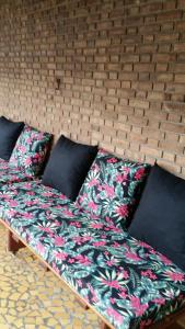 a bed with pillows on it in a room at Casa em Caraguatatuba in Caraguatatuba