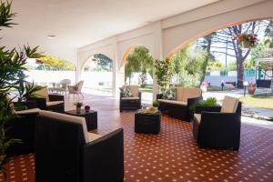 eine Lobby mit Sofas, Tischen und Stühlen in der Unterkunft Villa Aurelia -Seafront Apartment with Patio in Flumini di Quartu