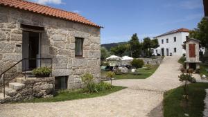 a stone house with a pathway leading to a building at Quinta Da Mouta in Vieira do Minho