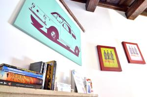 a shelf with books and pictures on a wall at POP Art B&B in Rome