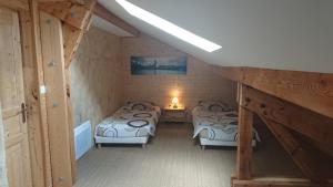 a attic room with three beds and a lamp at Le mas des Alberges in Le Bourg-dʼOisans