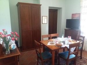 uma sala de jantar com uma mesa de madeira e cadeiras em "La Grancia" Country House em Treia