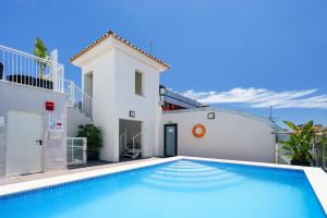 a villa with a swimming pool in front of a house at Exe Málaga Museos in Málaga