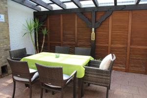 a green table and chairs on a patio at Casa Metzjersch in Gemünden