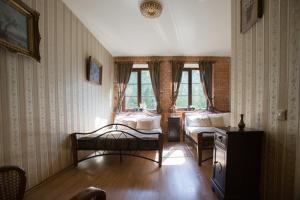 a bedroom with two beds and a table in it at Akmenių Dvaras in Akmeniai