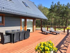 une terrasse avec une table noire, des chaises et des fleurs dans l'établissement Dīķmalas, à Roja