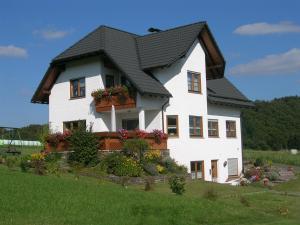 una gran casa blanca con techo negro en Ferienwohnung Mause, en Medebach