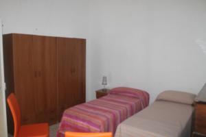 マリーナ・ディ・マンカヴェルサにあるAppartamento vicino al mareのベッドルーム1室(ベッド2台、木製キャビネット付)