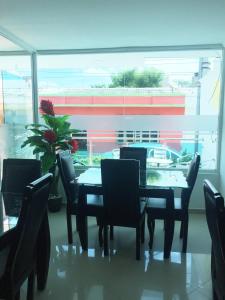 comedor con mesa, sillas y ventana en Karin Hotel, en Ríohacha