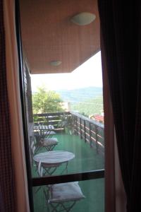 Habitación con vistas a un balcón con sillas y mesa. en Guest House Daskalov en Chervena Lokva